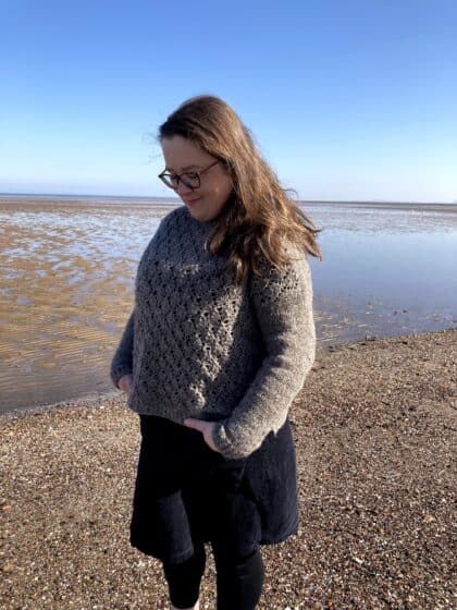 Louise on a beach wearing a new handmade sweater